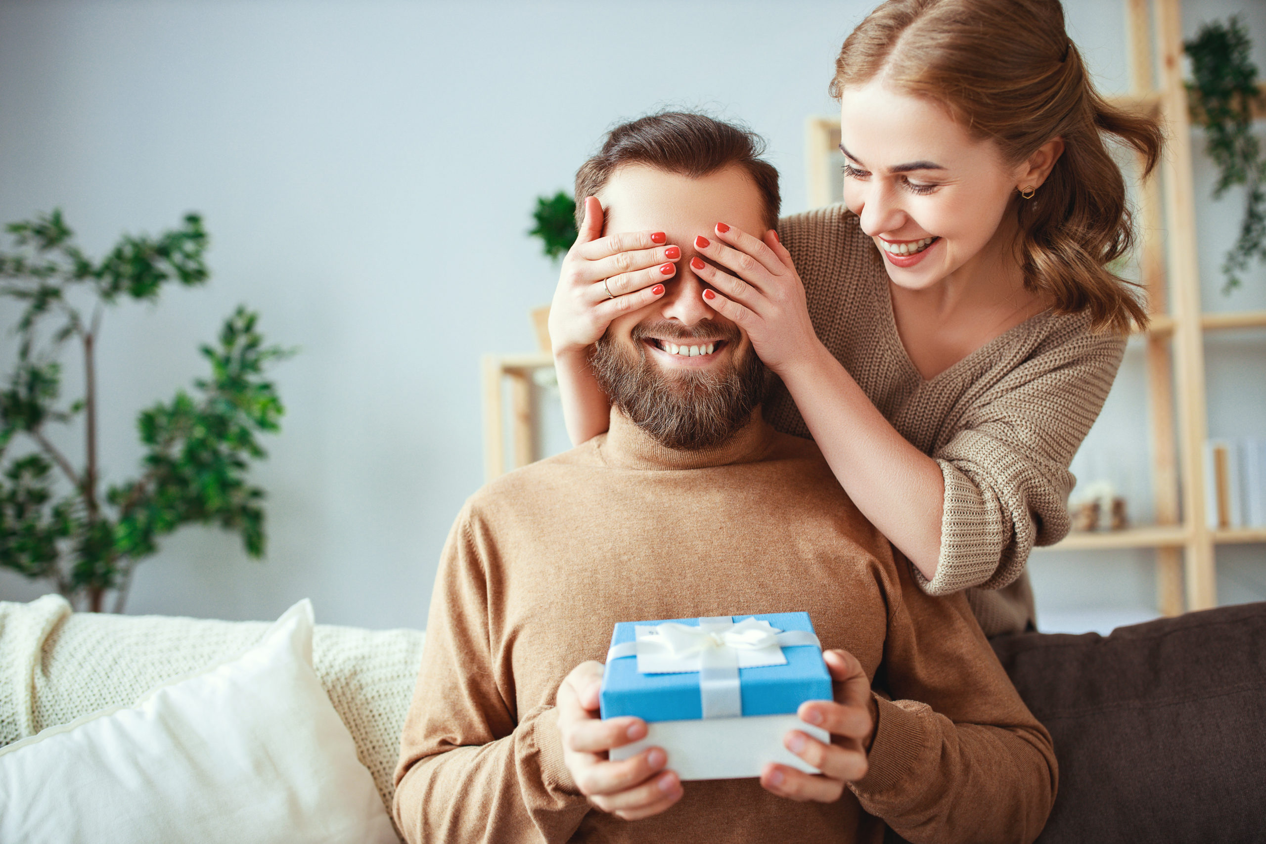 Happy married couple man and woman give a gift for holiday