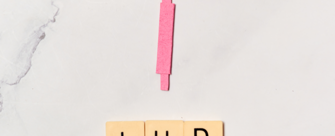 A pink IUD laying on a whit marbled surface.